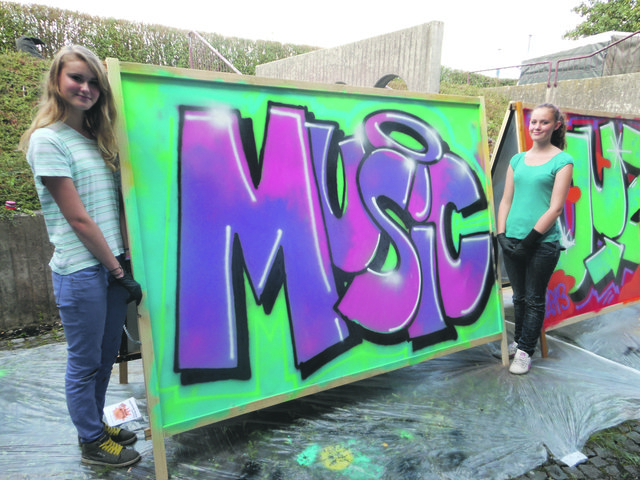 Cosima und Kimberly präsentieren ihr Sprayerkunstwerk.