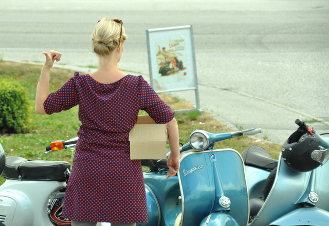Die junge Dame wartet auf eine Mitfahrgelegenheit - vorzugsweise eine Vespa.