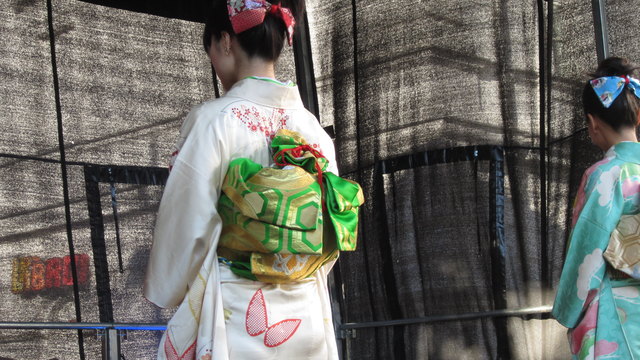 Besonders bemerkenswert auch der am Rücken kunstvoll gebundene Gürtel (Obi).