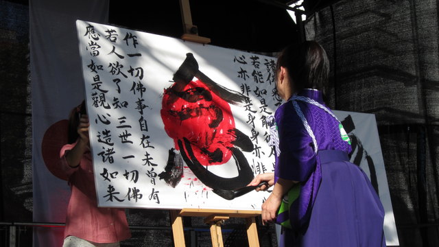 Eine japanische Kalligraphie entsteht auf einer Bühne in Ottakring.