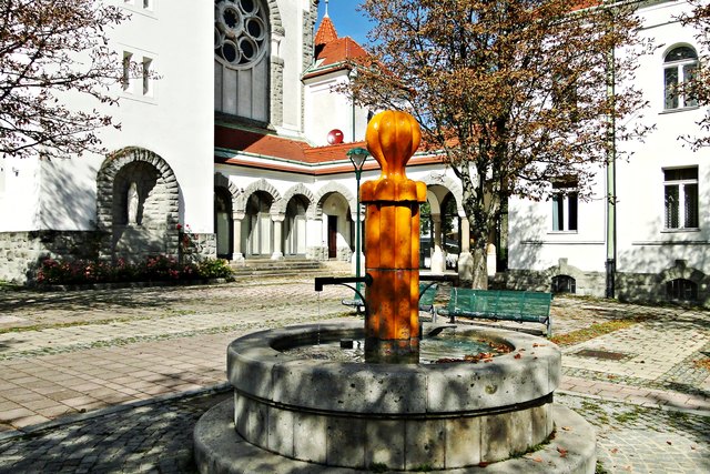 Brunnen im Hintergrund die Arkaden