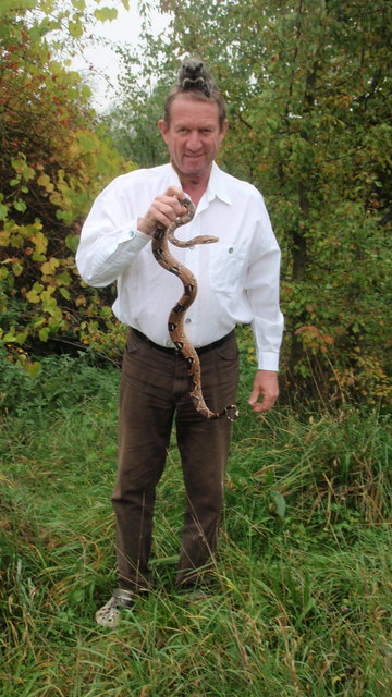Richard Weixler mit der entlaufenen Boa Constrictor. Auf seinem Kopf sitzt ein Affenbaby, dass er aufgezogen hat.