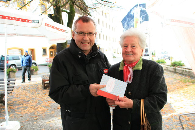 Dietmar Baku (ORF) überreicht Maria aus Mauterndorf ein Keksrezepte-Buch.