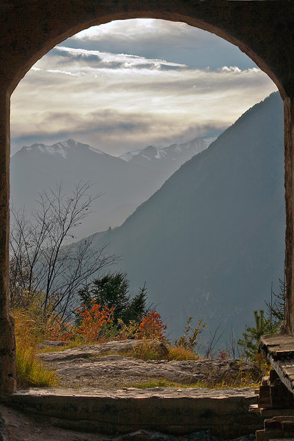 Das Burgtor ist meistens geöffnet und so kann man die Burgruine auch im Innenbereich betrachten. Durch das Burgtor ergibt sich ein Durchblick zur Burgruine Schrofenstein (an der Bergkante oberhalb von Stanz als Silhouette zu erkennen). Am Fuß vom Burghügel liegt der Wallfahrtsort Kronburg, über welchen die Via Claudia Augusta zum Schloss Landeck und weiter nach Fließ führt. © Ing. Günter Kramarcsik