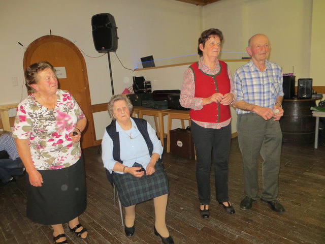 Sitzend unsere älteste Stammtischmusikanten auf der steirischen Harmonika mit stolzen 88 Jahren und Gratulanten