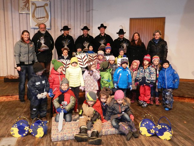 Die Erpfendorfer Kindergartenkinder nach der Aufführung der Martinslegende mit Kindergartenleiterin Katrin Steiner und ihrem Team, Erzähler Walter Rafelsberger und den Erpfendorfer Weisenbläsern