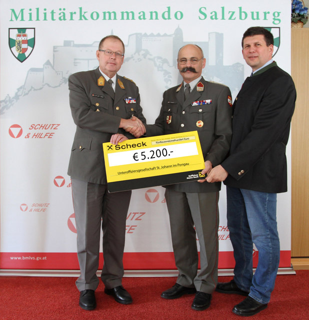 Vizeleutnant Erber übergibt den Scheck an Brigadier Hufler.