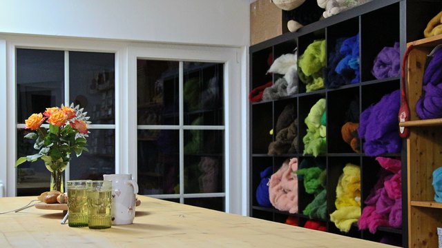 Ein großer Werktisch und Regale voller Schafwolle machen den Shop in Frankenburg zum perfekten Kursraum
