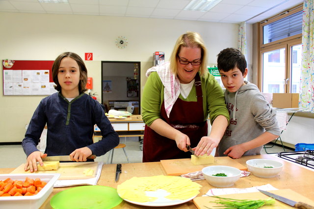 Gesundes Essen für alle: Martin (li.) und Eyüp (re.) helfen Klassenvorstand Karin Beranek beim Zubereiten der Jause