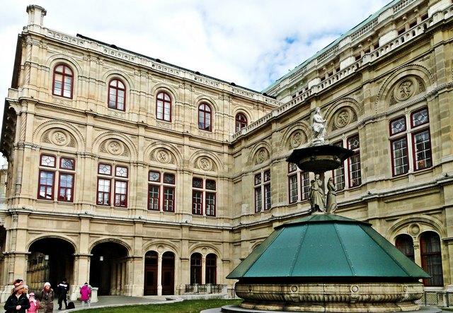 Westlicher Seitentrakt mit Arkadengang und der linke Brunnen mit den Figuren  "Musik, Tanz, Freude, Leichtsinn",
