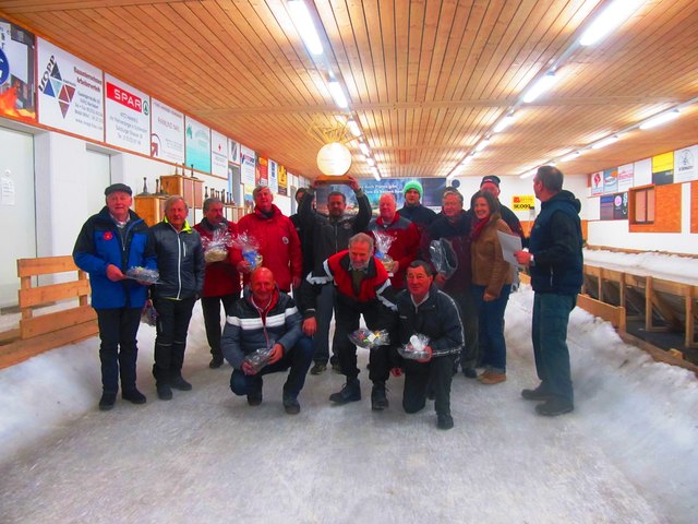 Die großen Drei des Pokalpreiseisschießen um die Hermann Angerer Trophy in Erpfendorf. vr. Die Gratulanten Resinger Hermann und Frau Sportreferentin Maria Braito; Rang 3 ESV Kitzbühel; Die Sieger des EC Oberndorf, Rang 2 links und kniend EV Fieberbrunn.