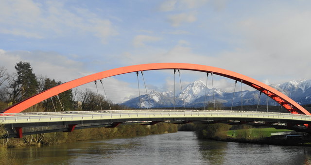 Die Friedensbrücke "Rote Brücke" an der Drau, eine Sehenswürdigkeit von Villach. Die Straße führt durch den Ortsteil Perau nach Magdalen.