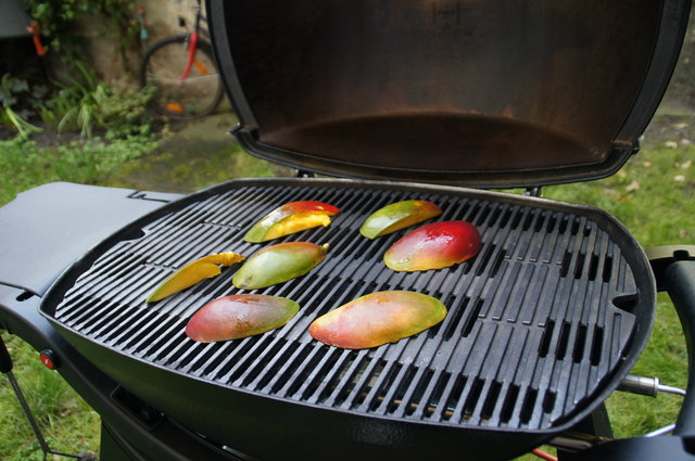 Die Mangos werden aufgeschnitten und mit der Fruchtfleischseite auf den heißen Grill (mittlere direkte Hitze) gelegt.