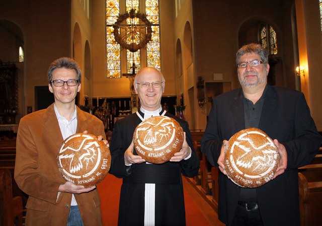 Pfarrgemeinderatsobmann Christian Mittendorfer, Pfarrer Alois Freudenthaler und Bäcker Karl Gehmair (v.l.) mit dem Heilig-Geist-Brot.