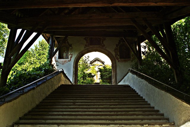 Zur Pfarrkirche führt ein mit der Jahreszahl 1687 bezeichnetes Portal mit überdachter Treppe. Am Portal mit abgefasstem Steingewände sind in drei bemalten Nischen eine Madonna mit Kind und die Heiligen Primus und Felicianus abgebildet