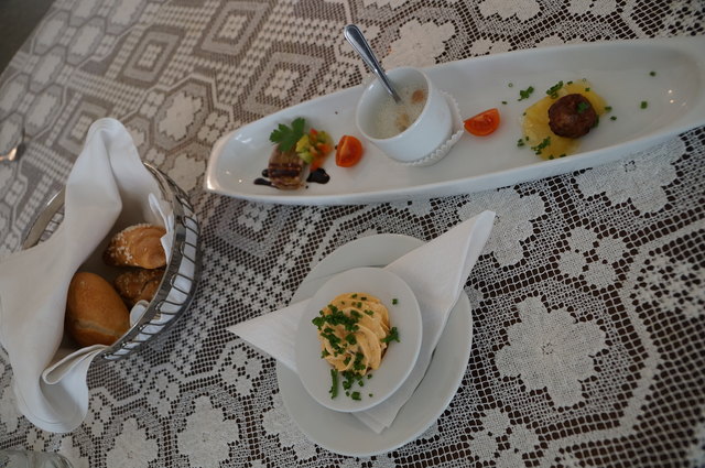 Der Gruß aus der Küche: Sülzchen vom Tafelspietz mit Himbeerpaprikavinaigrette, gesüßte Spargelschaumsuppe mit gebratenen Croutons und Wildschweinpraline mit Erdäpflsalat.