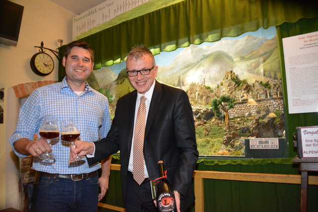 Andreas Frey und August Teufl stoßen mit der "Horny Betty" an – und eher untypischen Biergläsern – an. Im Hintergrund: Ein wunderbares Miniatur-Panorama von Maria Taferl.