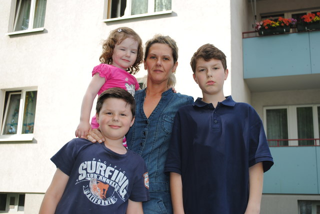 Renate Kozlica mit ihren Kindern Kathi (3), Michael (9) und Aleks (13) vor der Wohnhausanlage Wendstattgasse 11 in Favoriten: "Ich sind gerührt über die Hilfe, die unsere Familie nach dem Brand bei ihren Mitbewohnern erfahren durfte!", sagt die 3-fach Mutter.