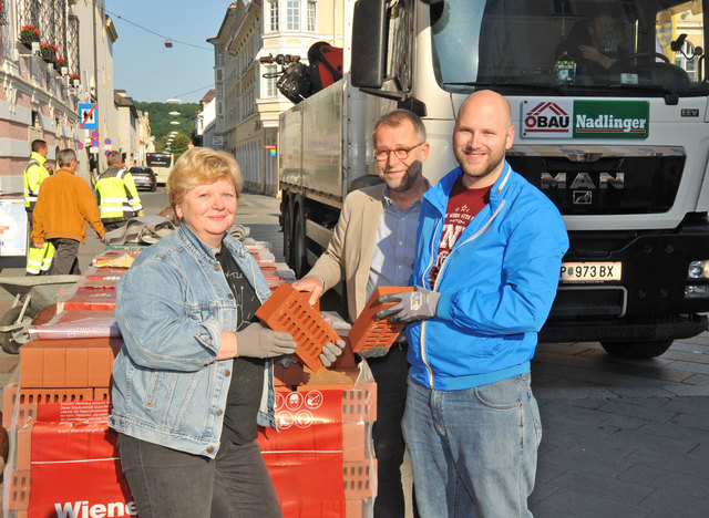 Offizieller Startschuss für das Urban Gardening: Nadlinger-Geschäftsführer Gerald Jöchl lieferte persönlich die für das Kräuterrad notwendigen Ziegel der Firma Wienerberger, die Thomas Kainz und Beate Steiner dankend entgegennahmen. | Foto: Stattgarten