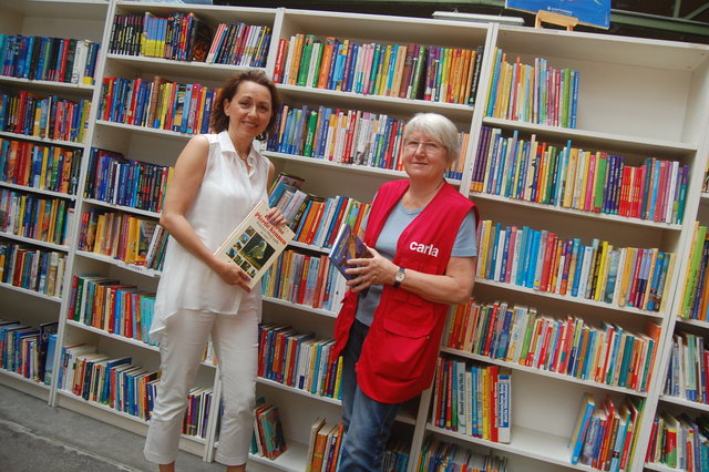 Elisabeth Mimra (links) bedankt sich bei der ehrenamtlichen Mitarbeiterin Renate Humitsch, die bei Carla in der Bücherausgabe hilft.