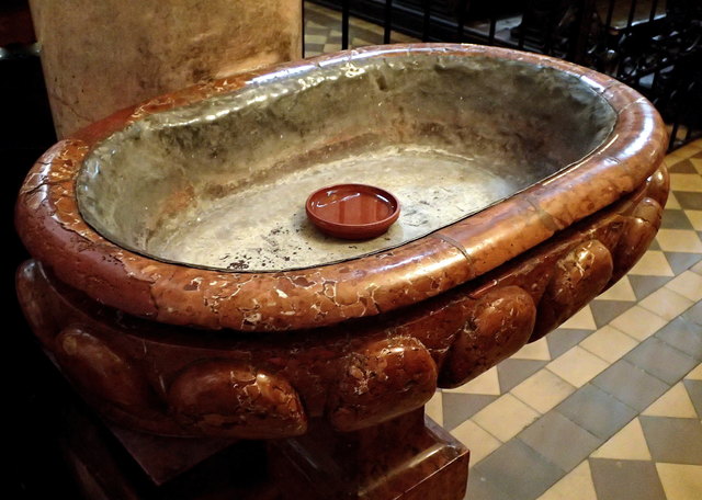 ist das Weihwasserbecken in der Paulaner Kirche (Wien, 4. Bezirk). Ich nehme an, es sind Hygienegründe für das kleine Blumenuntertopferl verantwortlich....