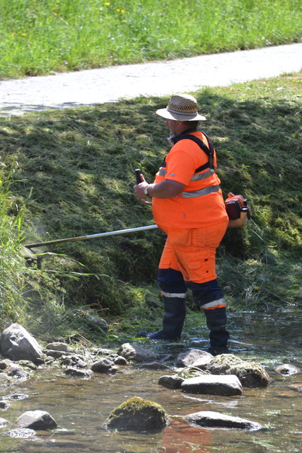 Ein Mitarbeiter des Magistrates beim Mähen der Böschung am Alterbach in Gnigl.
