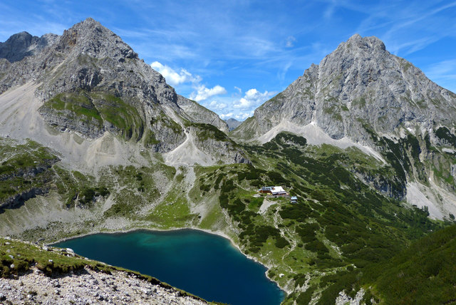 Drachensee mit Coburger Hütte (1.920 m) mit der Sonnenspitze 2.420 m  (im Hintergrund rechts). Aufstieg zuerst mit der Ehrwalder Almbahn zur Ehrwalder Alm - per Fuß weiter zum Seebensee - hinauf zur Coburger Hütte mit Drachensee.