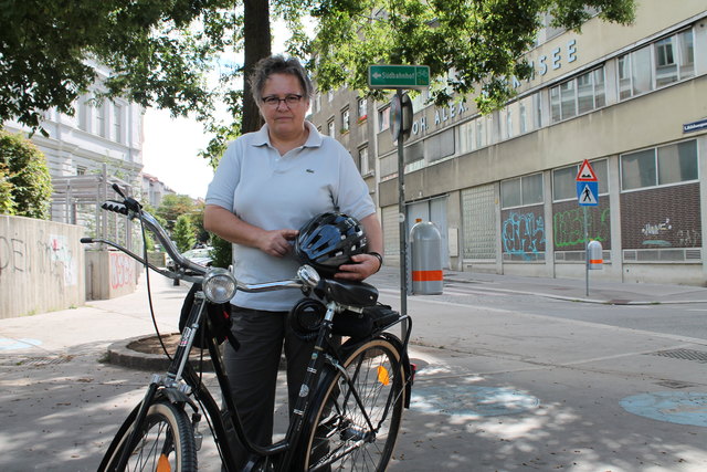Radfahrerin Barbara Schnabl vor dem irreführenden Straßenschild "Südbahnhof" statt "Hauptbahnhof"