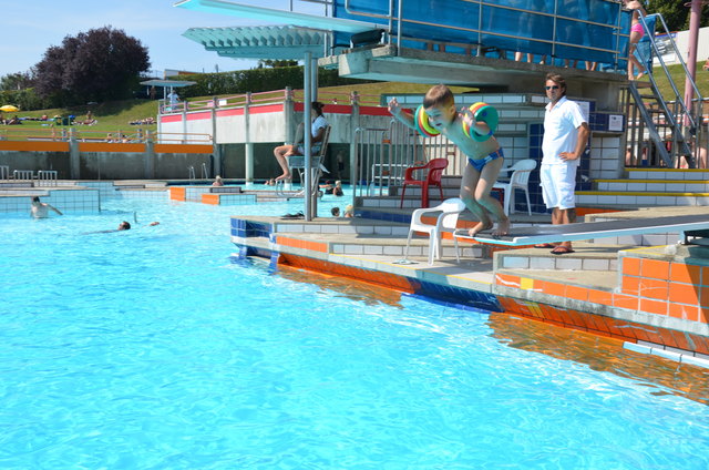 Der kleine Stanislaus Siller (4 ½) wagt den Sprung vom 1-Meter-Brett im blauen Sportbecken, immer unter dem wachsamen Auge der Bademeister.