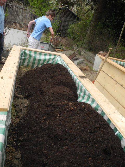 Verschiedene Schichten werden ins Hochbeet gefüllt