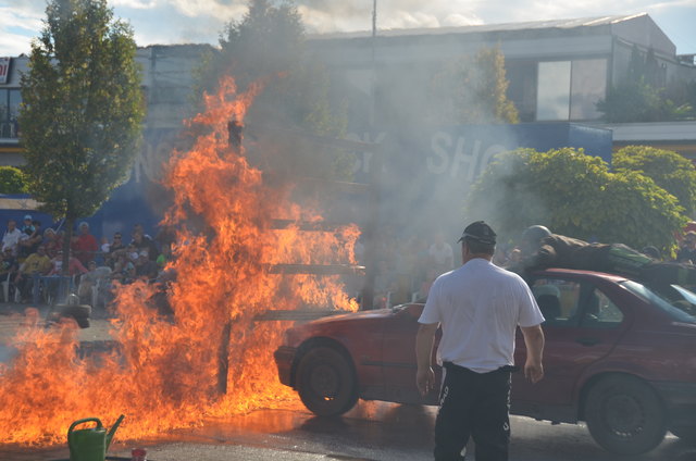 Der Stuntman am Autodach fuhr durch die Feuerwand bei der Tornado-Stuntman-Show