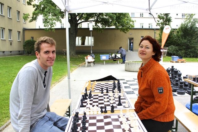 Die Schachtrainer Samuel (li) und Irina (re) spielen sich schon mal warm: Im Emil Fucik Hof gibt's ein open air mit gratis Schachunterricht für alle.