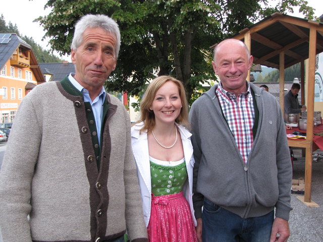 Gemeindemusikanten Hans Hirscher und Franz Moser nehmen Anna Wallinger, Gemeinde, in ihre Mitte.