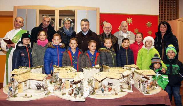 Diakon Norbert Wohlgemuth, Pfarrer Martin Müller, , VS-Leiterin Sabine Hochkircher mit  "Krippenbaumeister" Heinz Eichler mit seinem Team und den Kindern bei der Krippenausstellung. | Foto: KK/Schusser