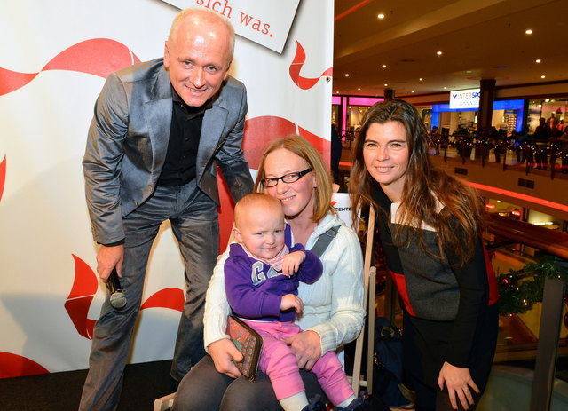 Andy Marek (l) und Centerleiterin Katharina Gfrerer (r) mit der stolzen Gewinnerin einer Urlubsreise und Ihrem Nachwuchs
