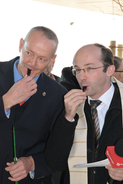 Bürgermeister Georg Holzner und Pfarrer Markus Männer probieren die Trillerpfeifen aus.