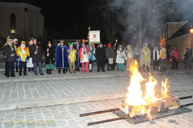 Der Fasching wird verbrannt. Im Hintergrund die Faschingsgilde Gumpoldskirchen und Bürgermeister Ferdinand Köck.