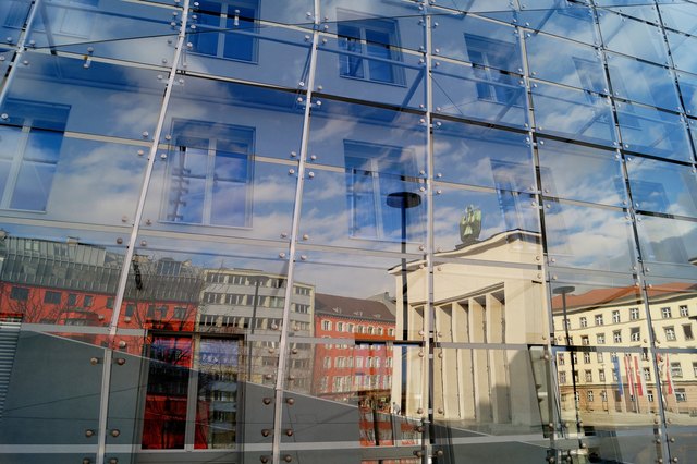 Der Innsbrucker Landhausplatz spiegelt sich in einer Glasfassade. Aufgenommen am 28.02.2015.