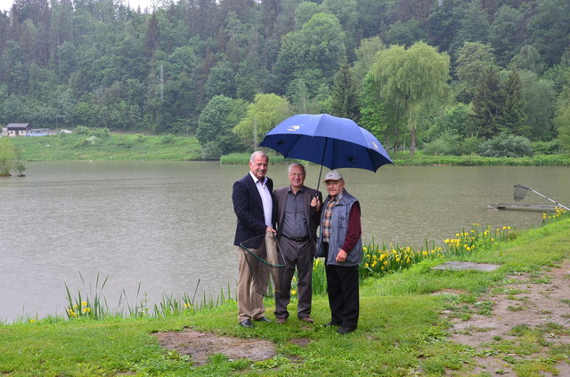 Vizebürgermeister Maximilian Jäger, Obmann Anton Mayer und Alt-Obmann Karl Hörmann im strömenden Regen vor dem Fischteich des Vereins.