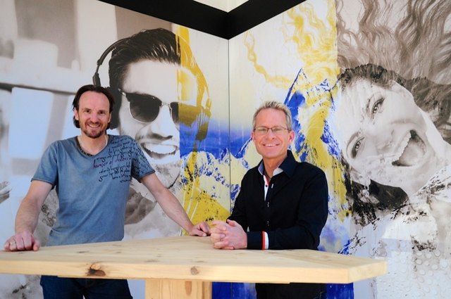 Hairstylist Martin Auer (li.) und Künstler Gerald Huber vor dem Bild "glücklich" auf der Fassade des Salons.