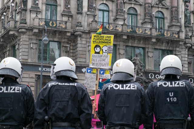 Polizisten hielten die Gegendemonstranten von der Kundgebung fern. "Muslime und Flüchtlinge willkommen", steht auf dem Schild.