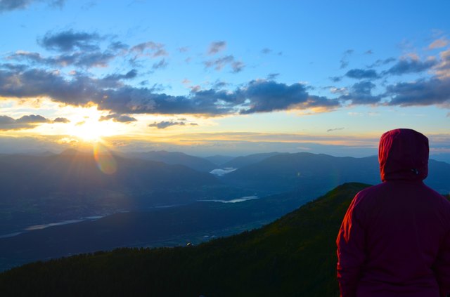 Bei kaltem Wind beobachtet eine Frühaufsteherin den Sonnenaufgang am Goldeck.