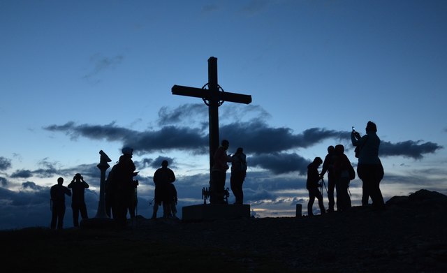 Silhouetten beim Gipfelkreuz vor Sonnenaufgang