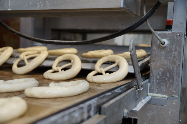 Die Brezen bekommen noch eine feine Schicht Lauge und Salz verpasst, danach geht es ab in den Ofen.