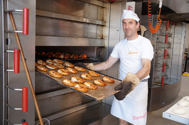 Hans holt die Brezen aus dem Ofen. Die ganze Backstube duftet bereits nach frischem Gebäck.