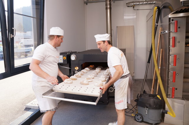 Die Brotlaibe kommen in den Holzofen.