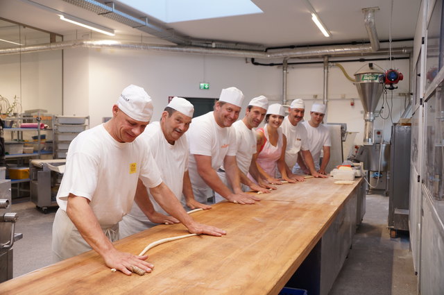Ausrollen und schwingen: die gesamte Mannschaft beim Brezen formen in der Backstube.