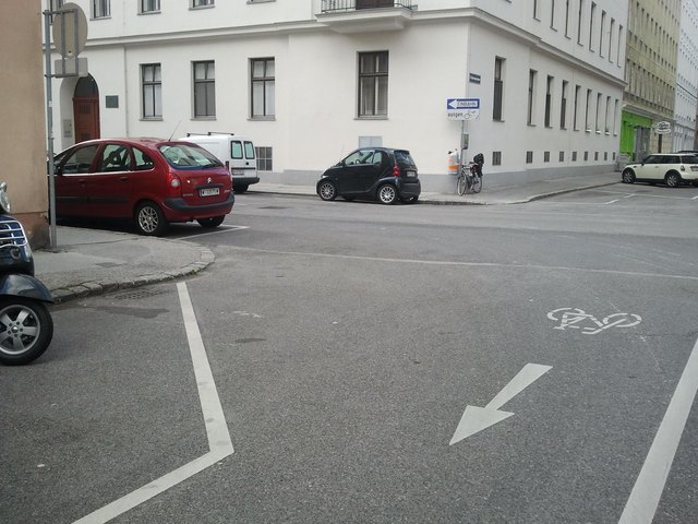 Sicht des von rechts kommenden Autofahrers blockiert durch roten Pkw.