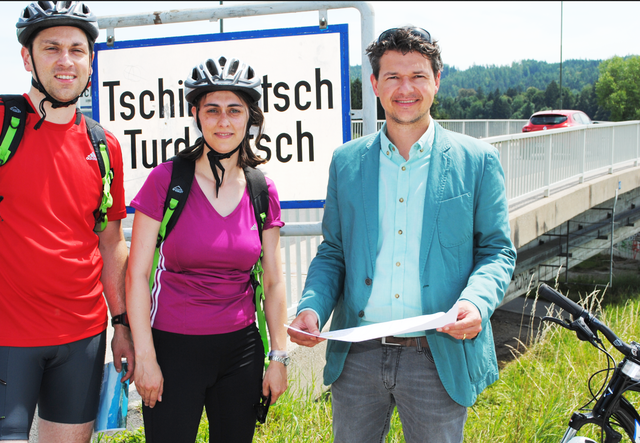 Am Ort des Geschehens: Peter Weidinger mit einem Urlaubspaar aus Augsburg vor der alten Tschinowitscher Brücke in Villach