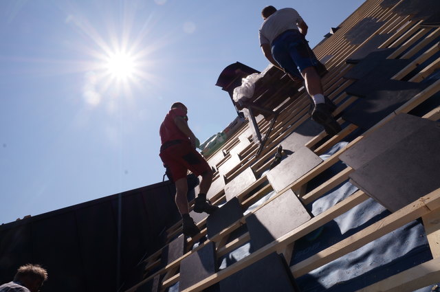 Die pralle Sonne macht den Dachdeckern von Spreitzer Bau die Arbeit nicht leicht.